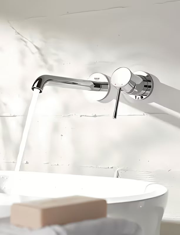 Kromirana podometna armatura za umivalnik Grohe Essence New z upravljalno ročico in stensko rozeto.