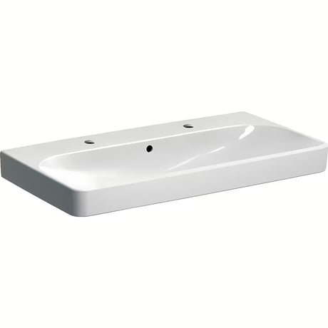 Bel viseči umivalnik Geberit Smyle Square 90x48 cm iz sanitarne keramike z dvema odprtinama pro armaturo.