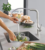 Grohe Essence New armatura za pomivalno korito z visokim vrtljivim izlivom in izvlečno prho v površini supersteel.