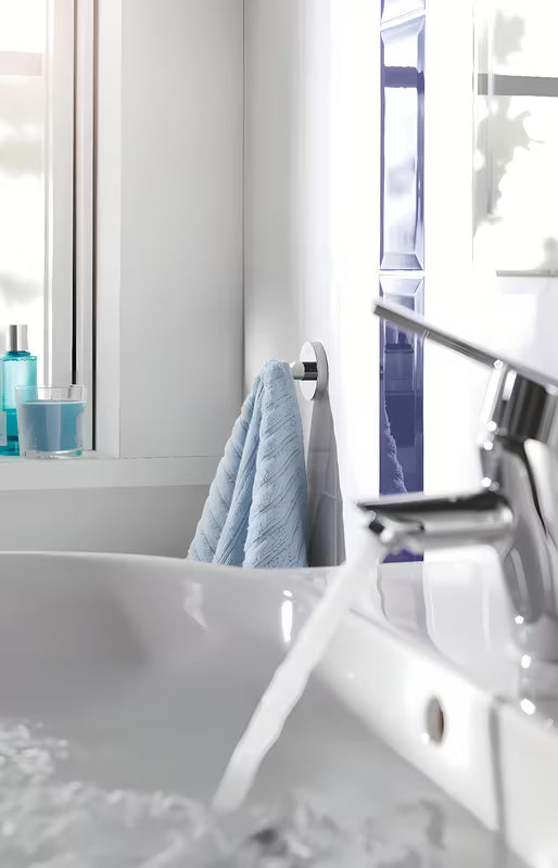 Kromiran kavelj za kopalni plašč Grohe Essentials s skritim pritrjevanjem na okrogli stenski ploščici.