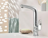 Visoka enoročna armatura za umivalnik Grohe Eurostyle New v kromu z vrtljivim izlivom in odtočno garnituro.