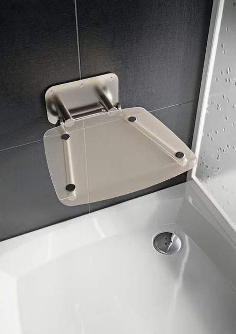 Zložljivo sedež za tuš Ravak Ovo B II s konstrukcijom od nehrđajućeg čelika i prozirnim poluprozirnim sjedalom Clear.