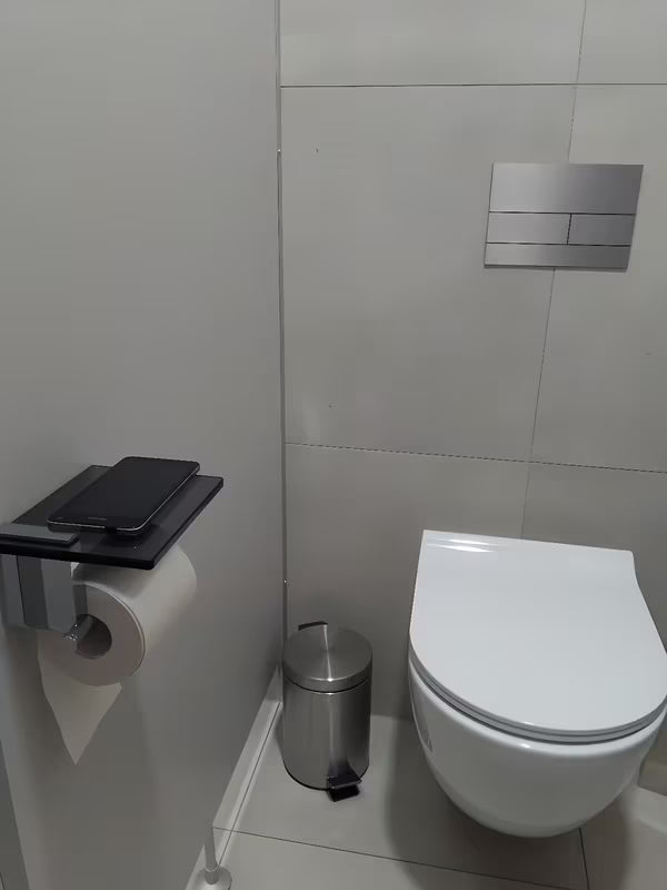 Črn držalo za toaletni papir SAT Cube Way z odlagalno polico iz kaljenega varnostnega stekla.
