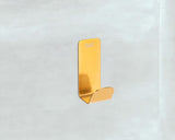 Kupaonski kavelj SAT Mood od nehrđajućeg čelika u brušenom zlatnom finišu, montaža lijepljenjem bez bušenja.