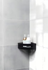 Kotna nerjaveči polica za tuši SAT v mat črni izvedbi z odstranljivim plastičnim vložkom.