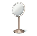 Potovalno kozmetično ogledalo Simplehuman Mini v barvi rose gold z osvetlitvijo Tru-lux Led in 10-kratno povečavo.